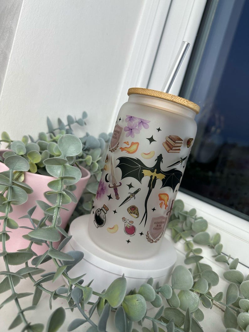 K&ouml;nnte beinhalten: Ein mattierter Glasbecher mit einem schwarzen Drachen, Sternen und anderen magischen Bildern. Der Becher hat einen Bambusdeckel und einen durchsichtigen Trinkhalm. Der Text auf dem Becher lautet "Dragon Mom Coffee"