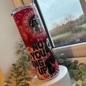 May include: Pink and black stainless steel tumbler with a ghost coffee logo and the text "No you hang up".
