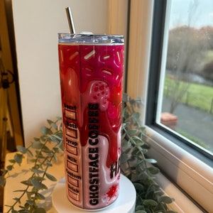 May include: A pink and red stainless steel tumbler with a graphic of a dripping ice cream cone and the text "Ghostface Coffee". The tumbler has a lid and a straw.