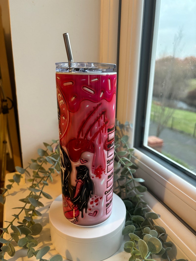 May include: A pink and white stainless steel tumbler with a graphic of a cartoon character with a dripping red heart and the text "Don't Be A D*ck" on the side. The tumbler has a clear lid and a stainless steel straw.