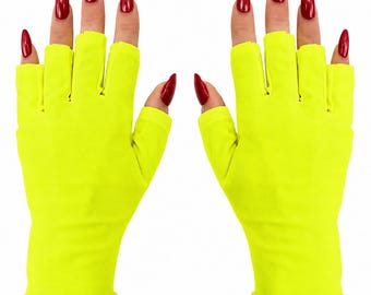 Puede incluir: Un par de guantes sin dedos de color amarillo neón confeccionados con una tela lisa de color sólido. Estos guantes cubren la palma y la muñeca dejando los dedos al descubierto, con una abertura separada para el pulgar en cada mano.