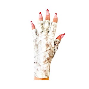 Puede incluir: Un par de guantes sin dedos blancos con un patrón de mármol marrón. Los guantes tienen un borde rojo alrededor de las aberturas de los dedos.