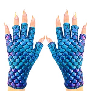 May include: A pair of fingerless gloves with a mermaid scale design in shades of blue and purple. The gloves have a textured appearance and are designed to cover the hand up to the knuckles.