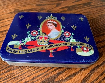 May include: A blue tin box with a gold trim and a picture of Queen Elizabeth II in a crown. The text on the box reads "Queen Elizabeth II Coronation 2nd June 1953".