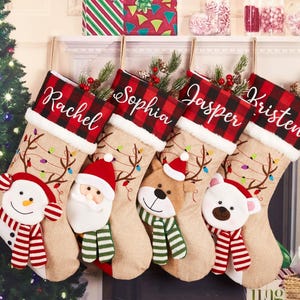 以下が含まれることがあります： レイチェル、ソフィア、ジャスパー、クリステンの名前が刺繍された5つのクリスマスストッキング。それぞれ赤と黒のチェック柄のカフス、ジュートのボディ、雪だるま、サンタ、トナカイ、ホッキョクグマのキャラクターが特徴です。