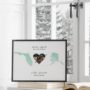 Puede incluir: Una impresión enmarcada con un mapa de los Estados Unidos y un recorte en forma de corazón con una foto de dos personas. El texto en la impresión dice "Miles Apart But Close To Heart" y "Lilly Amanda Best Friends Forever".