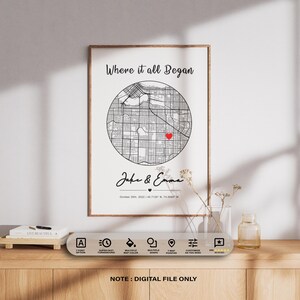 May include: Framed print featuring a black and white map with a red heart marker. The text "Where it all Began" is at the top, with names and a date below. The print is displayed on a wooden surface.