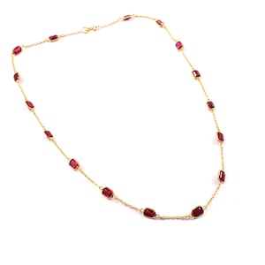 Op de afbeelding: Een delicate gouden ketting met rechthoekige, dieprode edelstenen. De edelstenen zijn gelijkmatig verdeeld over de fijne gouden ketting. De ketting wordt gepresenteerd tegen een witte achtergrond, wat het contrast tussen goud en rode stenen benadrukt.