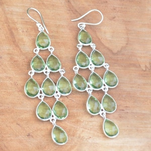 以下が含まれることがあります： 複数の緑色の涙型の宝石が付いたシルバーのドロップイヤリング