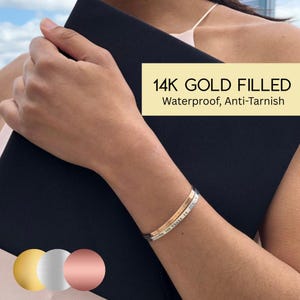 May include: A gold-filled bracelet with an inscription. The bracelet is 14k gold filled, waterproof, and anti-tarnish.