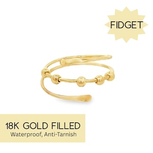 May include: Gold-toned ring with a beaded band and a twisted band. The ring is labeled "18K GOLD FILLED Waterproof, Anti-Tarnish" and "FIDGET".