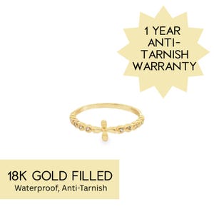 May include: Gold-filled ring with a cross design. The ring features small, clear stones and the text "18K GOLD FILLED Waterproof, Anti-Tarnish". A starburst graphic states "1 YEAR ANTI-TARNISH WARRANTY".