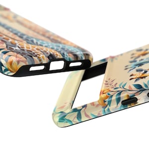 May include: Two phone cases with a floral and giraffe print. The cases are black and have a cutout for the camera lens.