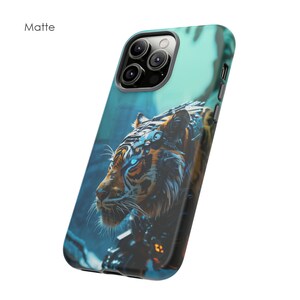 Puede incluir: Una funda para tel&eacute;fono azul turquesa con acabado mate presenta un gr&aacute;fico de un tigre con ojos azules brillantes. El tigre est&aacute; representado con detalles mec&aacute;nicos, lo que le da un aspecto futurista.