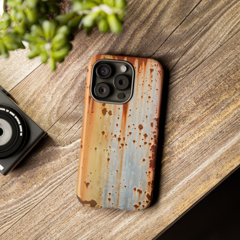 May include: A phone case with a rusty metal design. The case is made of a hard plastic material and has a raised camera bump.