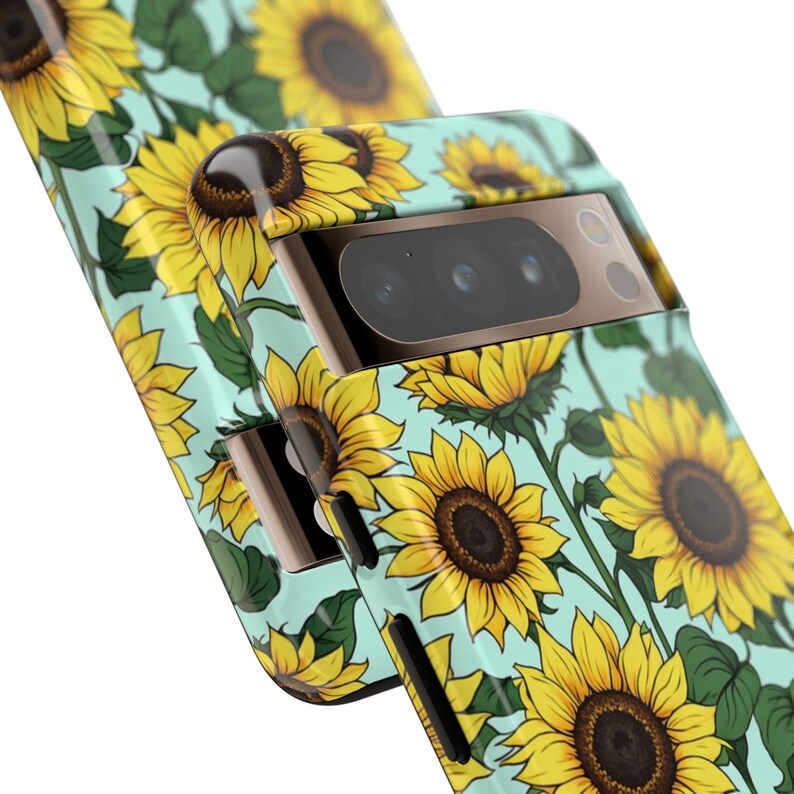 May include: A turquoise phone case with a sunflower pattern. The case has a gold trim and a camera lens cutout.