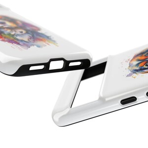 May include: A white phone case featuring a watercolour design of a dog's face. The case has a black bumper and a cut-out for the camera lens.