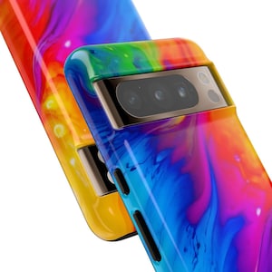 Może przedstawiać: Kolorowe etui na telefon z abstrakcyjnym wzorem w kolorze niebieskim, ż&oacute;łtym, czerwonym i fioletowym. Etui ma wystający element ochronny aparatu z trzema czarnymi obiektywami.