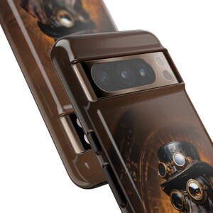 May include: A brown phone case with a steampunk design featuring a dog wearing goggles and a top hat. The case has a gold trim around the camera lens.