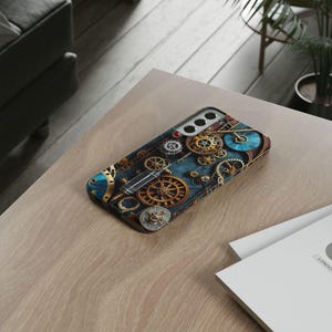 May include: A blue and gold phone case with a steampunk design featuring intricate gears and clockwork patterns.