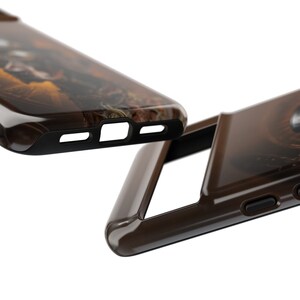 May include: Two brown phone cases with a camouflage pattern. The cases are made of a hard plastic material and have a glossy finish. The cases are designed to fit a smartphone.