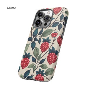 K&ouml;nnte beinhalten: Matte Handyh&uuml;lle mit einem botanischen Muster aus roten Himbeeren und gr&uuml;nen Bl&auml;ttern auf cremefarbenem Hintergrund. Die H&uuml;lle hat ein schlankes Design und ist f&uuml;r ein Smartphone geeignet.