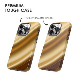 K&ouml;nnte beinhalten: Zwei Handyh&uuml;llen mit einem wirbelnden, abstrakten Design in Gold- und Braunt&ouml;nen. Die H&uuml;llen sind mit "Premium Tough Case" und "Glossy or Matte Finishes" beschriftet.