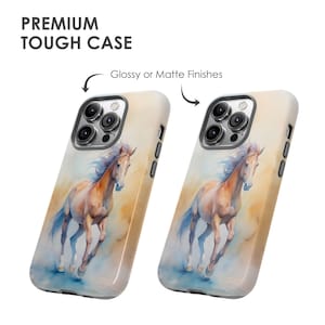May include: Two phone cases featuring a watercolour painting of a brown horse running. The cases are white with a glossy or matte finish. The phone cases are for an iPhone 14 Pro Max.