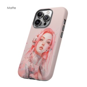 May include: A pink phone case with a matte finish featuring a digital illustration of a woman with pink hair wearing headphones. The case has a cutout for the camera lens.