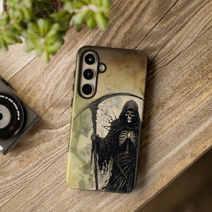 May include: A black and white phone case with a graphic of the Grim Reaper holding a scythe. The background is a faded yellow and brown.