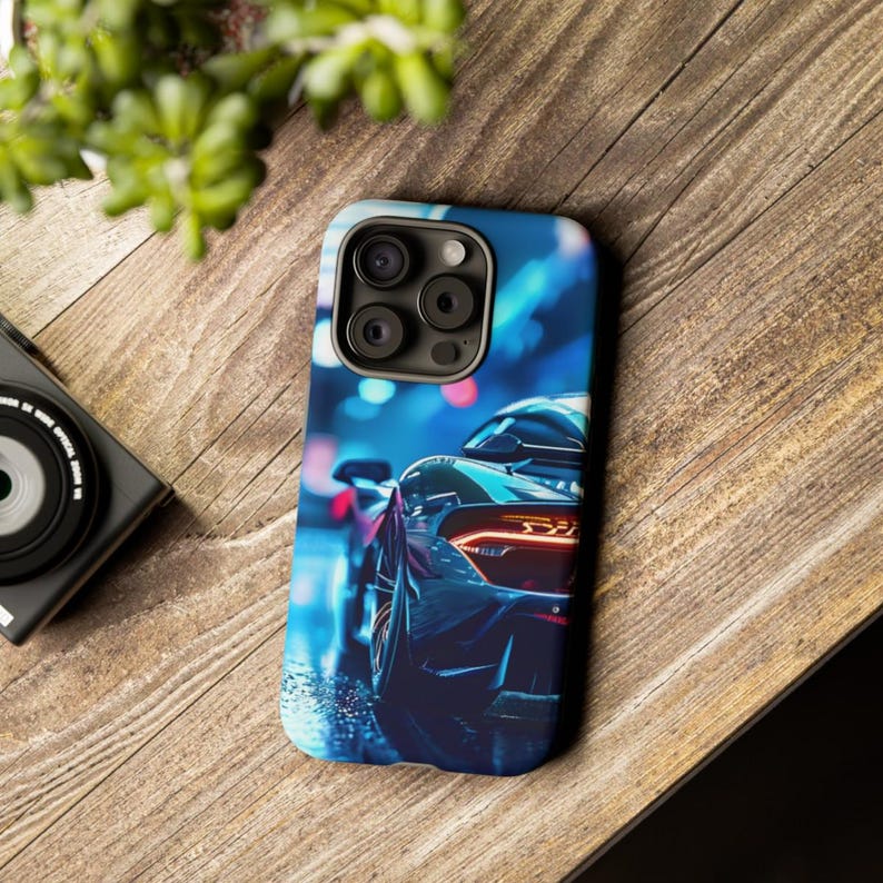 May include: A blue and black phone case featuring a picture of a blue sports car driving at night. The case has a camera cutout with three lenses.