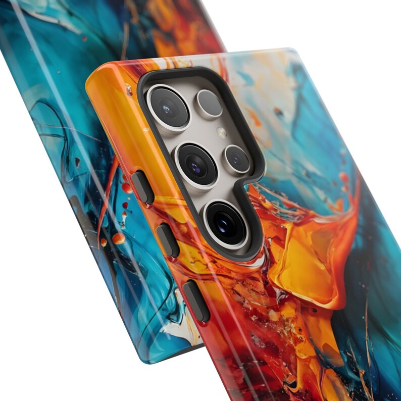 Puede incluir: Una funda para tel&eacute;fono con un dise&ntilde;o abstracto colorido con remolinos de azul, naranja y amarillo. La funda tiene un recorte de c&aacute;mara negro con tres lentes.