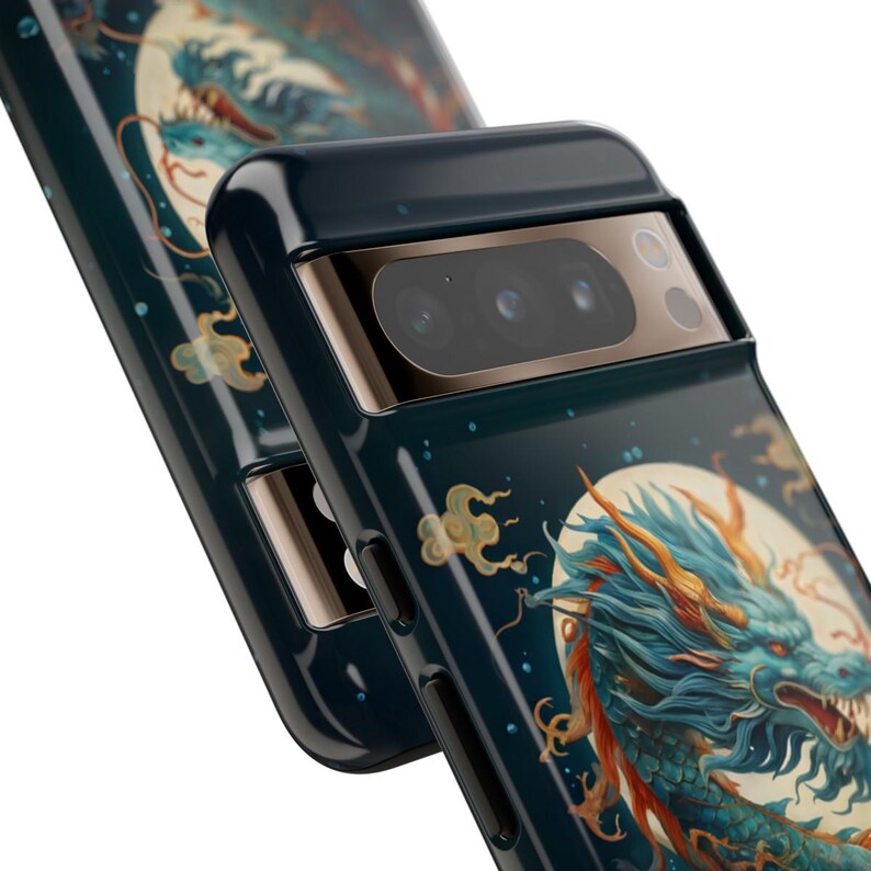 K&ouml;nnte beinhalten: Eine schwarze Handyh&uuml;lle mit einem Drachen-Design. Die H&uuml;lle hat eine Kameraobjektivabdeckung mit drei Objektiven. Der Drache ist blau und gold und von Wolken umgeben. Der Hintergrund ist dunkelblau mit Sternen.