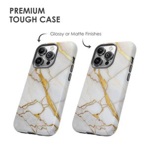 May include: Two white and gold marble iPhone cases with a glossy or matte finish. The cases have a white background with gold veins.