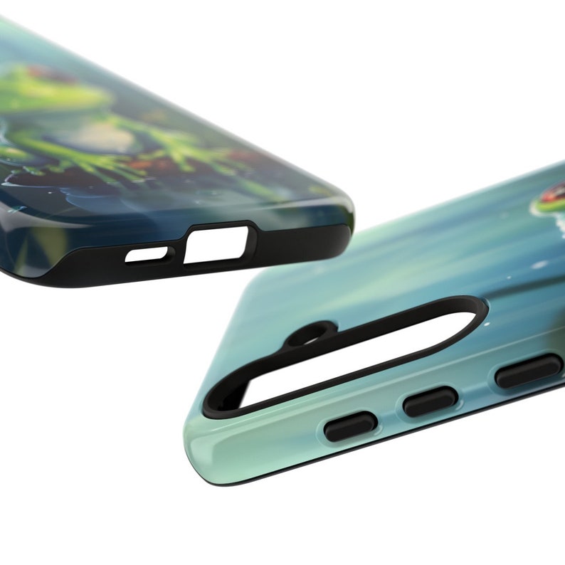 May include: A green and blue phone case with a frog design. The case has a black bumper and a clear back.
