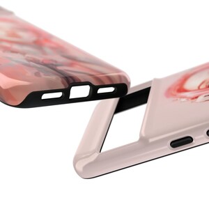 May include: Two pink and white marble phone cases with black accents. The top case is open and the bottom case is closed.