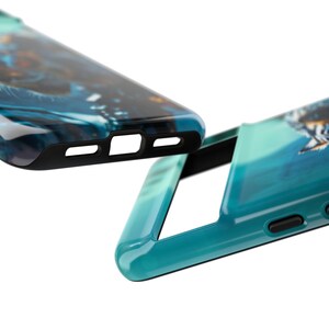 Puede incluir: Dos fundas para tel&eacute;fono de color azul turquesa con ribete negro. Una funda tiene un dise&ntilde;o abstracto azul y negro, la otra tiene un dise&ntilde;o degradado azul y verde.