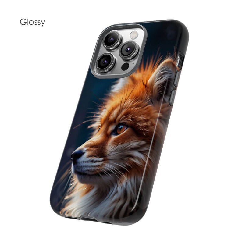 以下が含まれることがあります： 赤いキツネが横を向いて見ている、アップの写真がプリントされた光沢のある携帯電話ケース。キツネは白い胸と黒い鼻をしています。