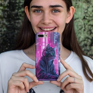 May include: A phone case featuring a black cat wearing headphones and a hoodie, set against a pink and blue neon cityscape. The cat has green eyes and is looking to the right.