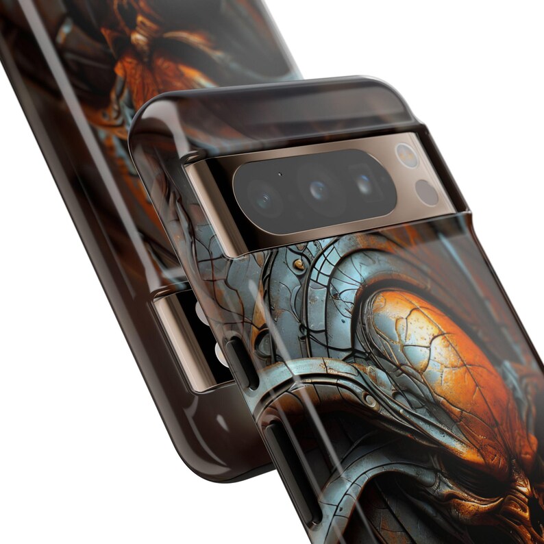 May include: A black phone case with a detailed, metallic, and orange design. The case has a raised camera lens cover.