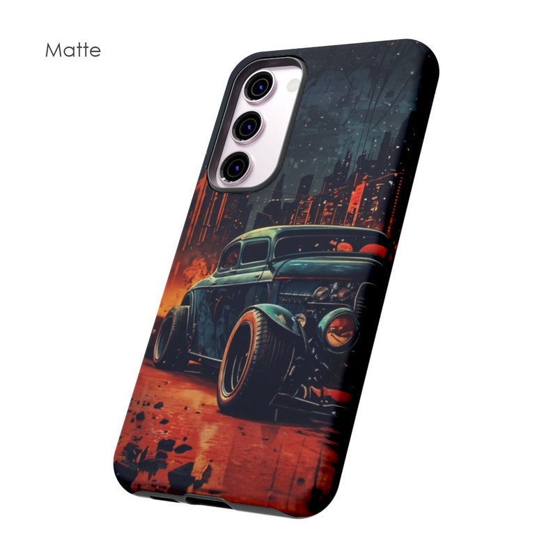 May include: A black phone case with a matte finish featuring a vintage hot rod car illustration against a city skyline backdrop.