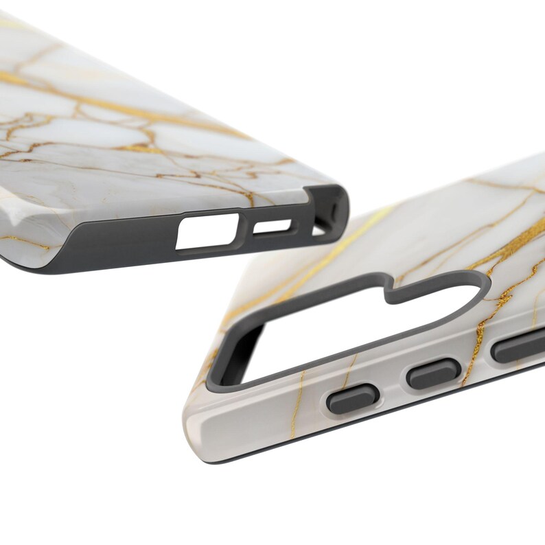 May include: A white and gold marble phone case with a black bumper. The case has cutouts for the camera and buttons.