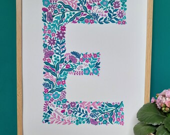 Puede incluir: Una impresión enmarcada de una letra E floral con el nombre Elsie y la fecha 10 de enero de 2013.