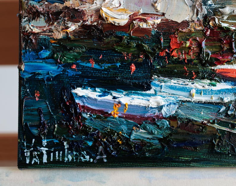 May include: Close-up of an oil painting with impasto brushstrokes. The artwork depicts a landscape with dark blues, greens, and whites. The artist's signature is visible in the lower left corner. The painting is on a canvas.