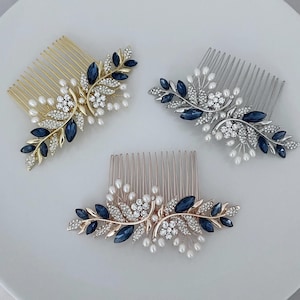 May include: Three hair combs with a floral design featuring blue and clear rhinestones, pearl accents, and gold, silver, and rose gold finishes.