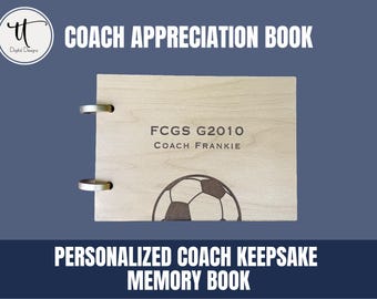 Puede incluir: Un libro de agradecimiento para entrenadores de madera clara con anillos de encuadernación de metal plateado. El libro presenta el texto "COACH APPRECIATION BOOK" y "PERSONALIZED COACH KEEPSAKE MEMORY BOOK". La portada está grabada con un balón de fútbol y el texto "FCGS G2010 Coach Frankie".