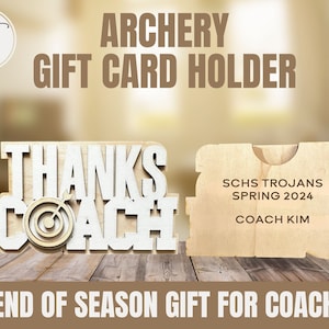 May include: Wooden gift card holder shaped like an archery target with the words "Thanks Coach" and a target with an arrow in the center. The holder is on a woodgrain background. The text "SCHS Trojans Spring 2024 Coach Kim" is on the back of the holder.