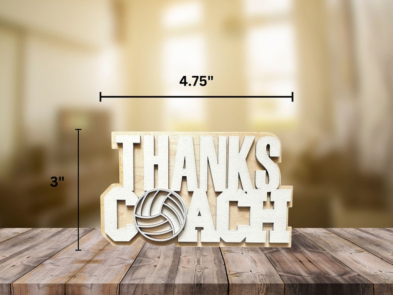 May include: A wooden sign that says "THANKS COACH" with a volleyball graphic. The sign is 4.75 inches wide and 3 inches tall. The text and volleyball are white, and the background is a light wood color.