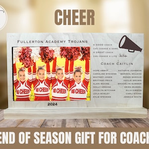May include: A wooden plaque featuring a photograph of a cheerleading squad wearing red and white uniforms. The plaque is inscribed with the words "Fullerton Academy Trojans" and "Cheer". It also includes the text "Coach Caitlin" and a list of names. This plaque is a gift for a coach at the end of the season.