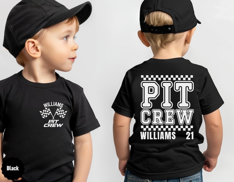 Op de afbeelding: Twee kinderen dragen zwarte T-shirts met witte tekst en geruite vlaggen. De tekst op de shirts zegt "PIT CREW" en "WILLIAMS 21".